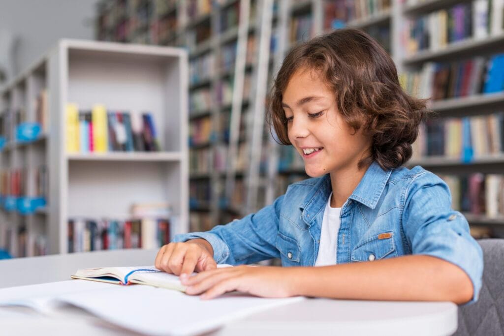 A young boy studying in a library, representing the focus and learning benefits of ADA Memory Techniques Classes in Kannur and Bangalore, building 10X Confidence.